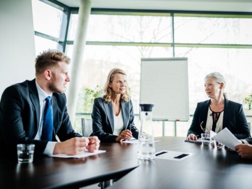 Réunion d'actionnaires au sein d'une entreprise avec deux femmes et un homme assis autour d'une table