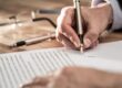 Main d'un homme d'affaire en train de signer avec un stylo un pacte d'actionnaires