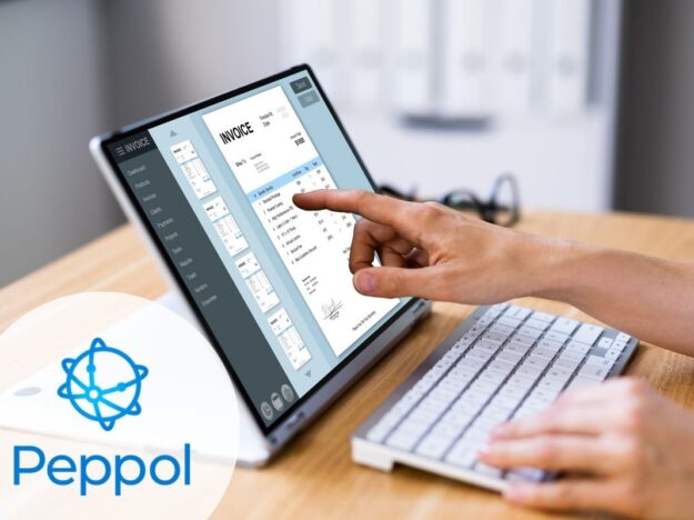 Bureau en bois avec un tablette posée dessus ouverte sur une facture Peppol